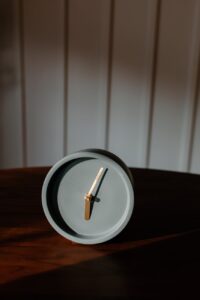 an analogue modern design clock in the wooden table