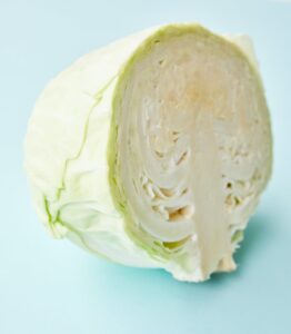 cut fresh white cabbage on blue background